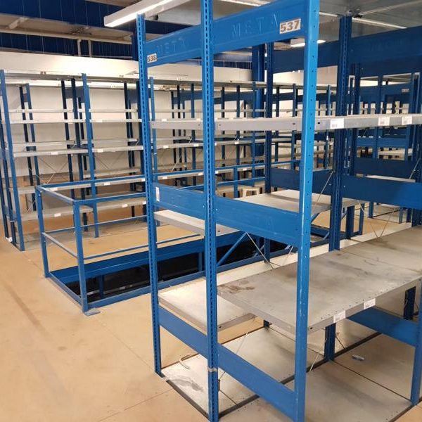 Leere blaue Regale in einem großen Raum mit Betonboden.