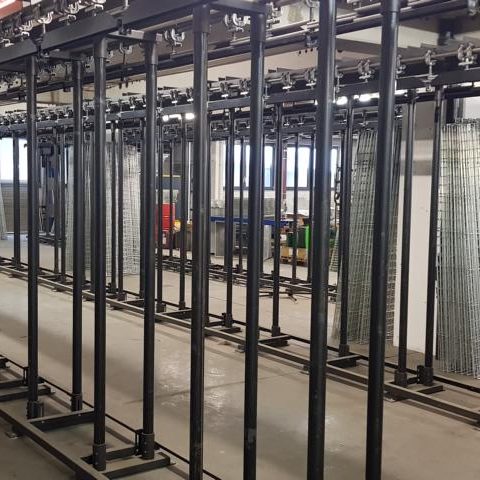 Metallgestell mit mehreren vertikalen Stangen in einer Industrieumgebung.