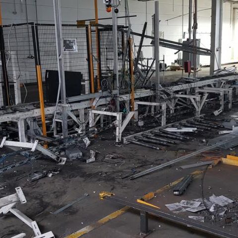 Industrieanlage mit beschädigten Maschinen und verstreutem Material auf dem Boden.