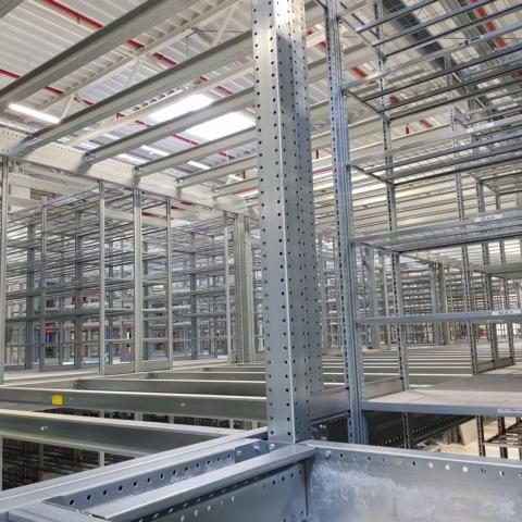 Metalregale in einem Lagerraum, mehrere Regalsysteme in Reihen angeordnet.