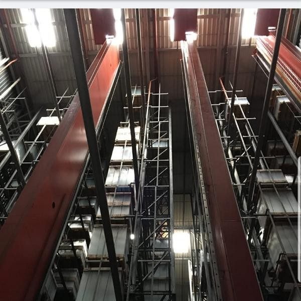 Blick auf hohe Regale in einem modernen Lager mit rotem Stahlrahmen.