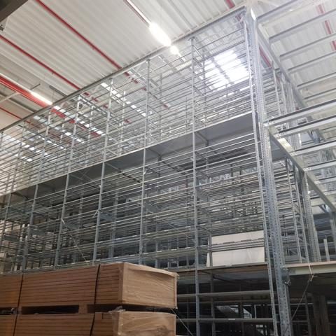 Hochregallager mit mehreren Stapeln von Regalen und Holzpaletten im Vordergrund.