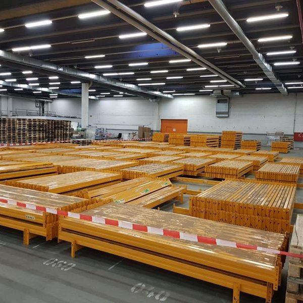 Lagerraum mit Stapeln von Holzpaletten und einem unauffälligen Sicherheitsabsperrband.