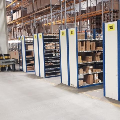 Regalreihen mit Kisten und Paketen in einem modernen Lagerhaus.