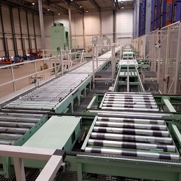 Fabrikhalle mit Förderband und Maschinen für die Produktionslinie.