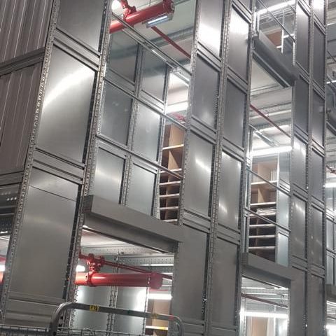 Moderner Industriegebäudebereich mit Metallverkleidung und großen Fenstern.